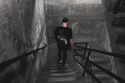 男人穿黑色的衬衫走下楼梯
